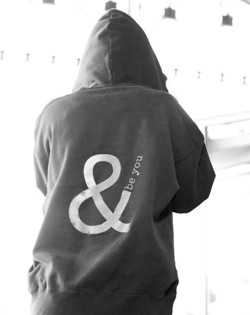 Imagen en blanco y negro del tronco superior de una persona con la hoodie Cistierna vista desde la parte trasera.