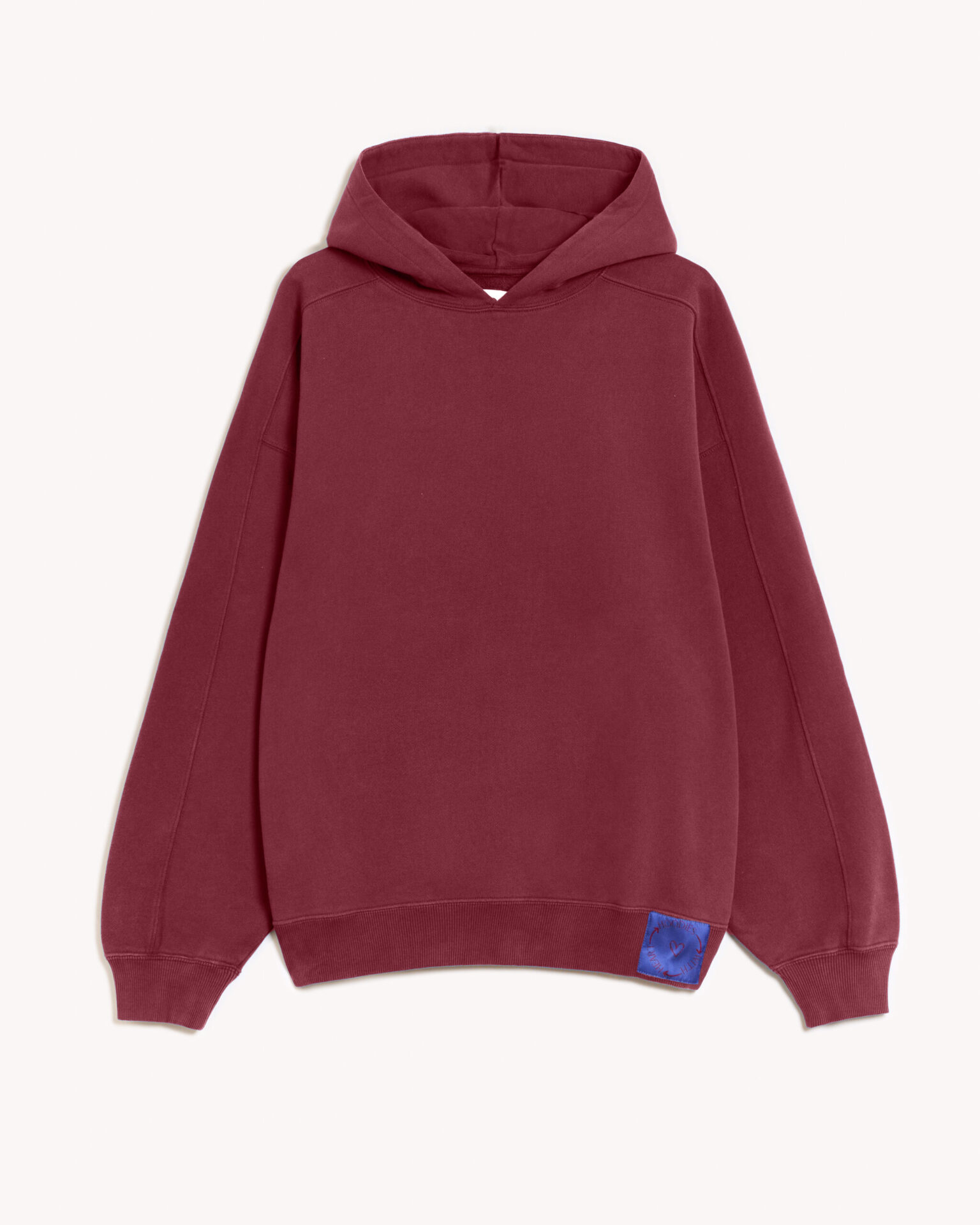 Imagen de la parte delantera de la hoodie modelo Cistierna con capucha en color granate. En la parte izquierda del elástico inferior de la sudadera lleva cosido en tela el logo de hoodies with heart. Modelo unisex de corte holgado y hombro caído.