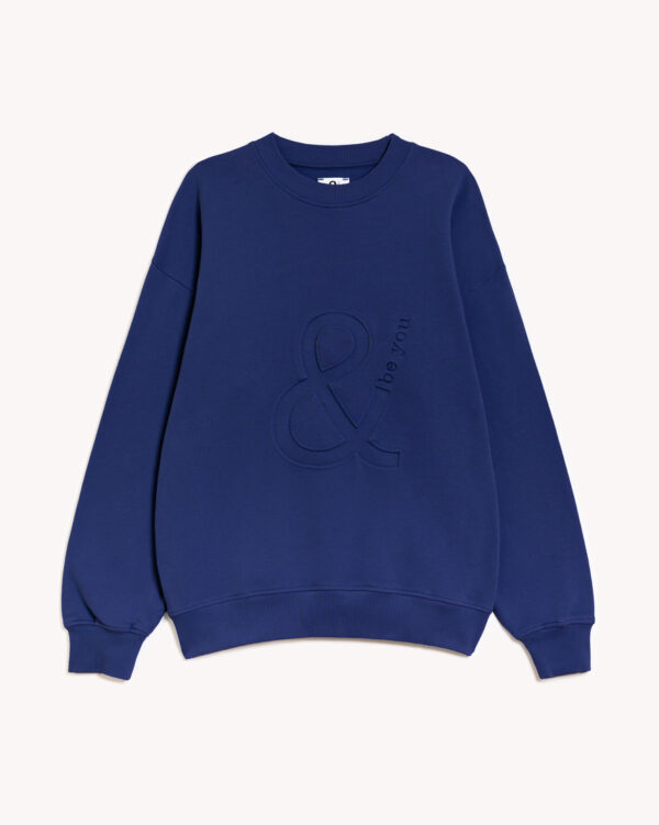 Imagen de la parte delantera de la sudadera modelo adrados sin capucha en color azul intenso con el logo de and be you brand en bajo relieve. Modelo unisex de corte holgado y hombro caído.
