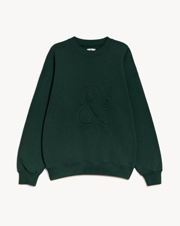 Imagen de la parte delantera de la sudadera modelo adrados sin capucha en color verde botella con el logo de and be you brand en bajo relieve. Modelo unisex de corte holgado y hombro caído.