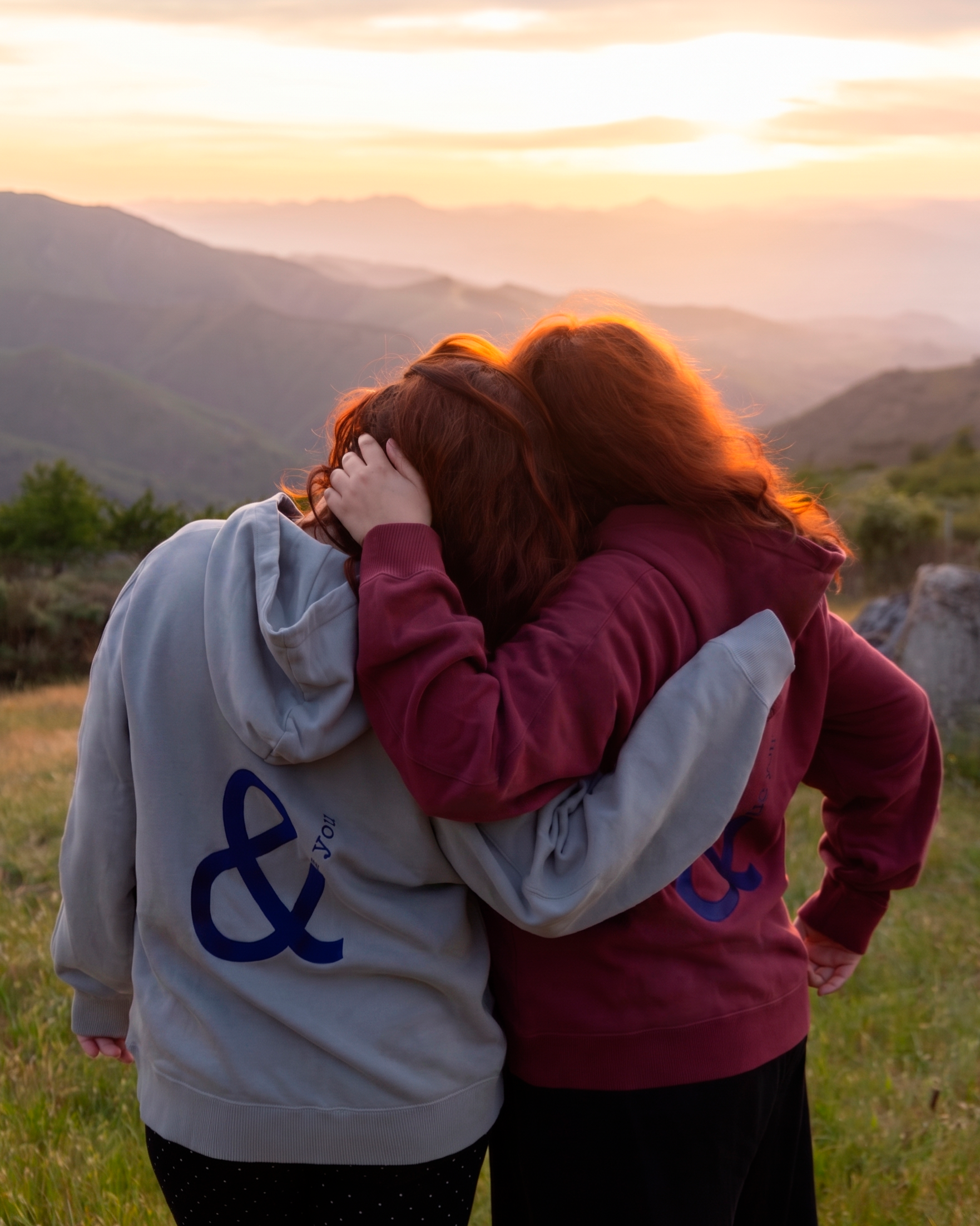 mujer con una sudadera en verano en la montaña al atardecer